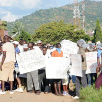 Des jeunes arborant des pancartes lors des affrontements avec des policiers ©Iwacu