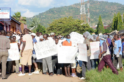 Des jeunes arborant des pancartes lors des affrontements avec des policiers ©Iwacu