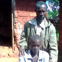 Jérémie Mbayahaga et son fils : « Il est revenu le corps mutilé, la peau écorchée, il ne pouvait pas aller à la selle. Aujourd’hui, c’est un handicapé » ©Iwacu