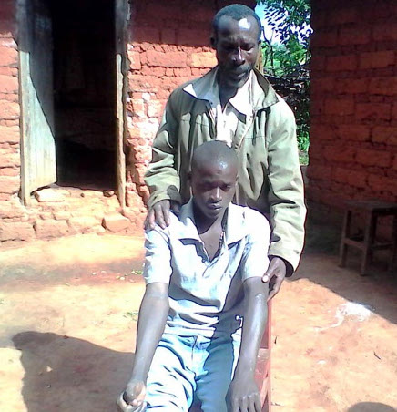 Jérémie Mbayahaga et son fils : « Il est revenu le corps mutilé, la peau écorchée, il ne pouvait pas aller à la selle. Aujourd’hui, c’est un handicapé » ©Iwacu