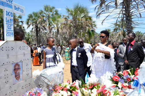Christiane Hicuburundi alias Toyota, épouse de feu Datus Nshimirimana et ses enfants déposant une gerbe de fleur à la tombe du défunt ©Iwacu