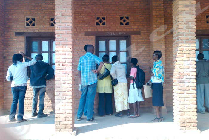 Some teachers coming to inquiry about their cases on the noticeboard at Gitega Urban Lycée