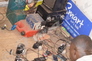 Jean Claude Habonimana in his shop where he charges phones for money using solar energy