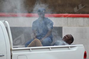 An arrested young man suffering ill-treatment in the police vehicle 