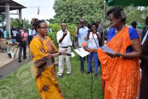 Aimée Laurentine Kanyana, handing a certificate of release to a recipient of the presidential pardon