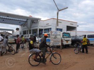 Bicycle taxis ready to take over cars queuing at a dry fuel station