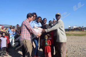 Charity Club members and BAIA headmaster distributing food to the Batwa community of Buterere. 