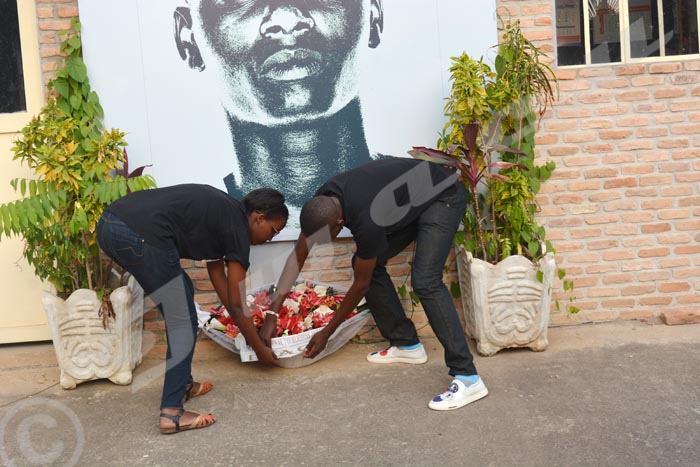 Iwacu Journalists laying flowers beneath Jean Bigirimana’s portrait in Iwacu compound