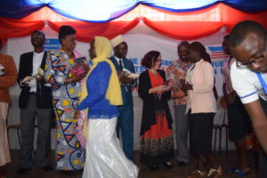 The Director of SACODE and the US Ambassador to Burundi alongside educators in Kayanza distributing sanitary pads to school girls