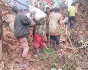 People unloading the overturned truck in Rwizingwe area where the accident occurred