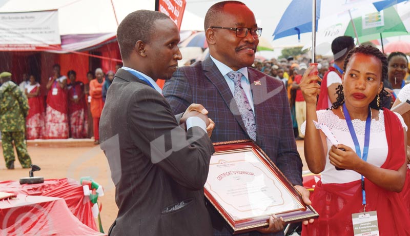 Parfait Gahama receiving a Certificate of Merit awarded by OBR Commissioner-General AudaceNiyonzima.