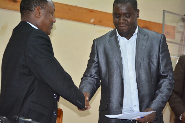 Après la signature de l’acte d’engagement, Claude Nkurunziza, directeur de la radiotélévision Rema, serre la main du président du CNC Richard Giramahoro.