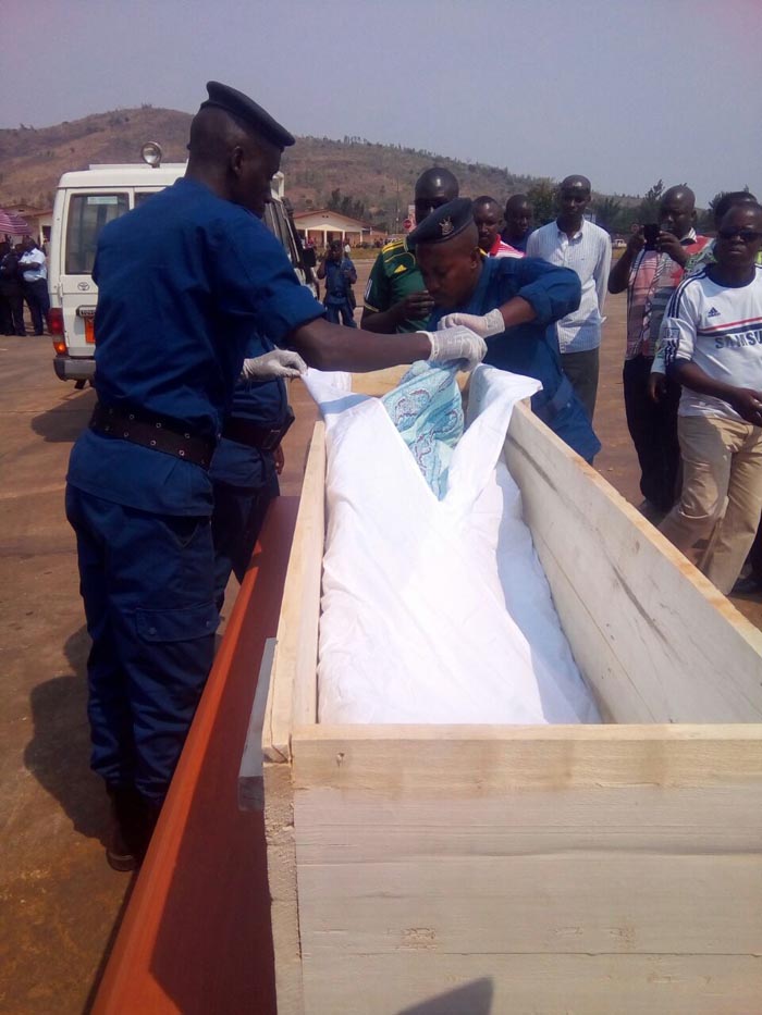 Le corps de l’une des victimes sur le point d’être déplacé du cercueil rwandais vers un cercueil burundais.