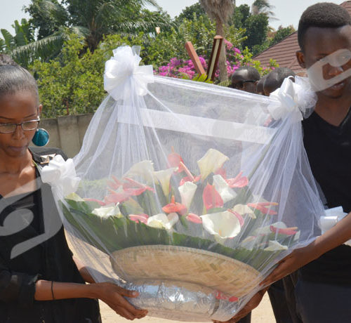 Arnaud Igor Giriteka (à droite) et Anaïs Hashazinka, deux plus jeunes journalistes d'Iwacu déposent une gerbe de fleurs. Photo prise dans les enceintes d'Iwacu le 22 juillet 2018 ©Onesphore Nibigira/Iwacu
